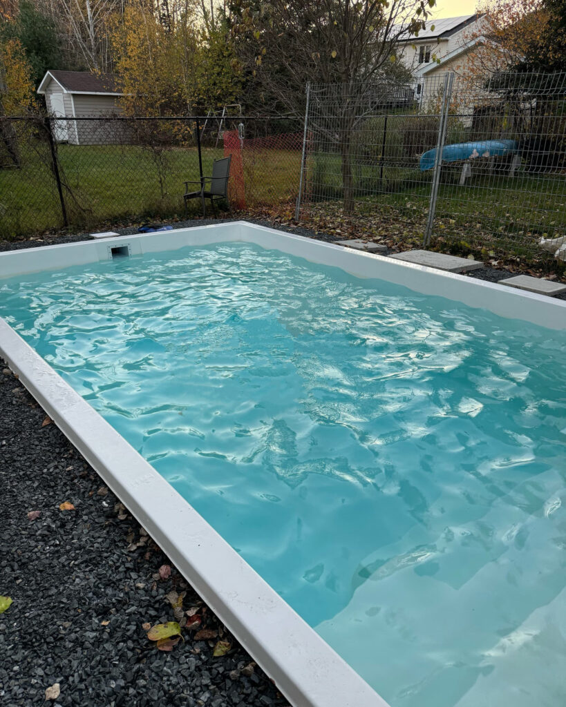 a fibreglass pool filled with water in a fredericton back yard.
